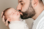 Vater küsst Baby auf der Backe